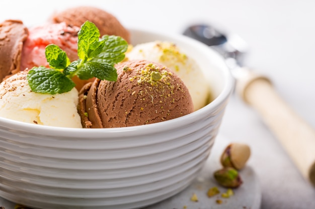 Assorted ice cream in white bowl.