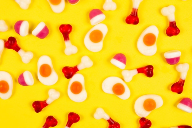 Assorted jelly sweets on yellow background Pattern