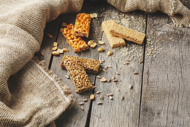 Assorted kozinaki,, with burlap fabric. Country style. Delicious sweets from the seeds of sunflower, sesame and peanuts, covered with shiny glaze.