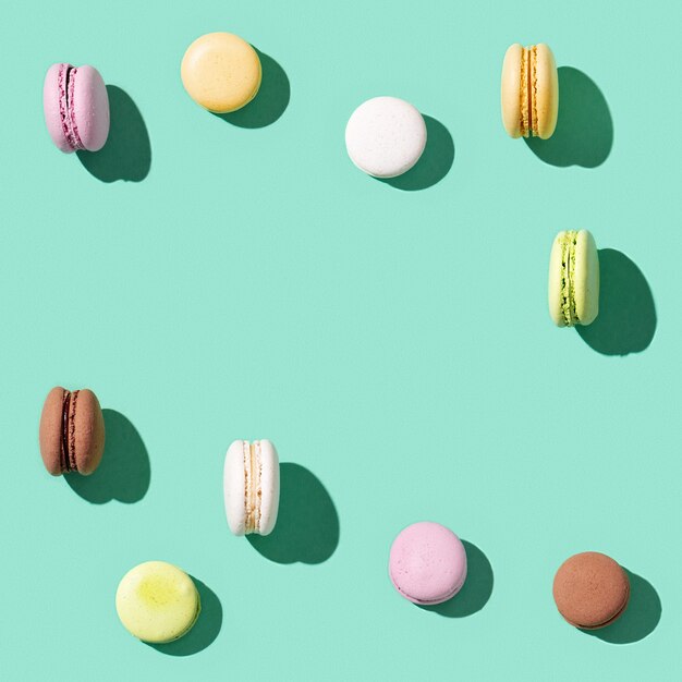 Assorted macaroons on bright blue green colored