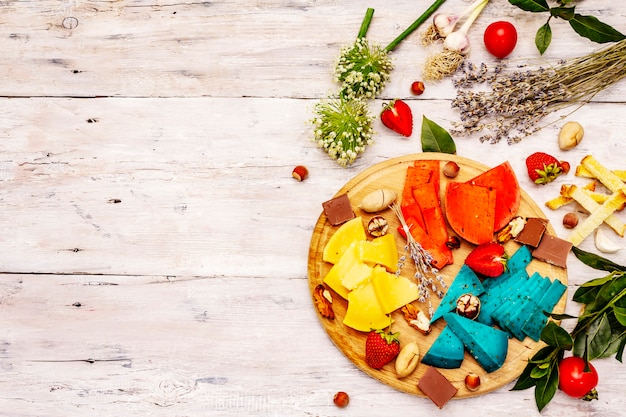 Assorted multi colored hard Dutch cheeses on white boards background