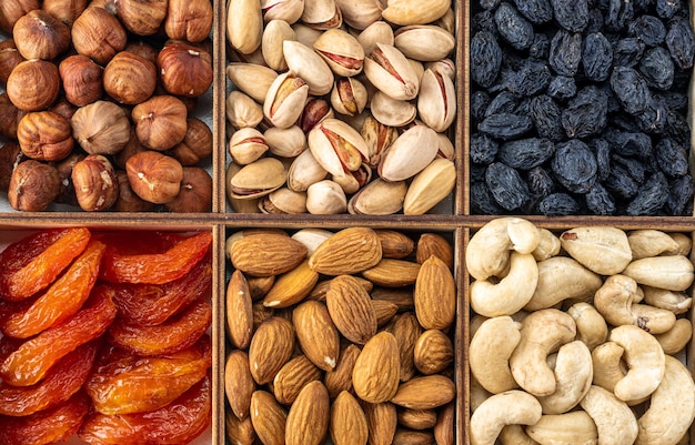 Assorted nuts and dried fruit collection Assorted nuts almonds pistachio cashews walnut Organic mixed nuts background Healthy food useful microelements and vitamins