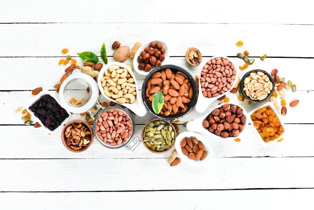 Assorted nuts on a white wooden background Top view Free space for your text