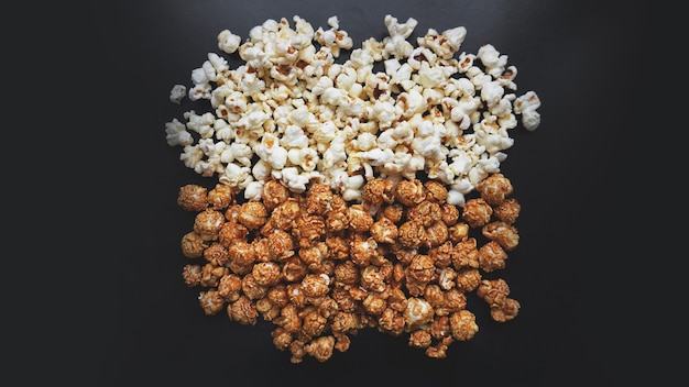 Assorted popcorn set background. Sweet and salty popcorn on black background. Still life, top view, flat lay. Concept cinema and entertainment