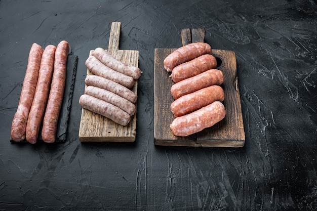 Assorted raw homemade sausages, on black table