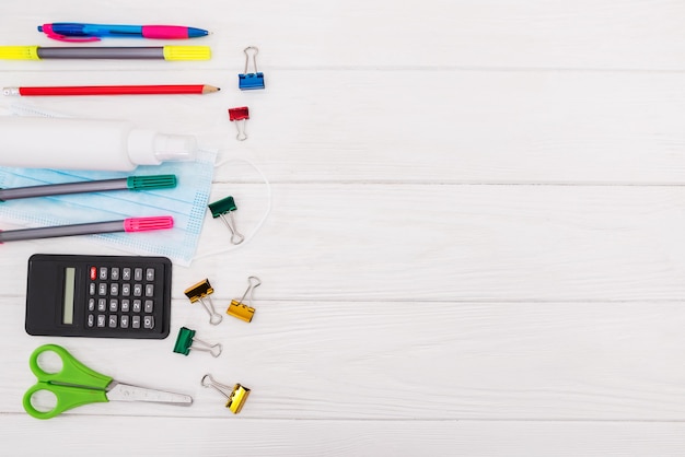 assorted school supplies and a mask on a white 