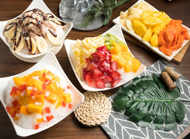 Assorted seasonal fruit and ice cream mango banana apple pineapple served in bowl isolated on table side view of taiwan food