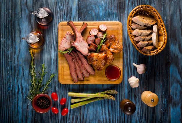 Assorted smoked meat on rustic wooden background