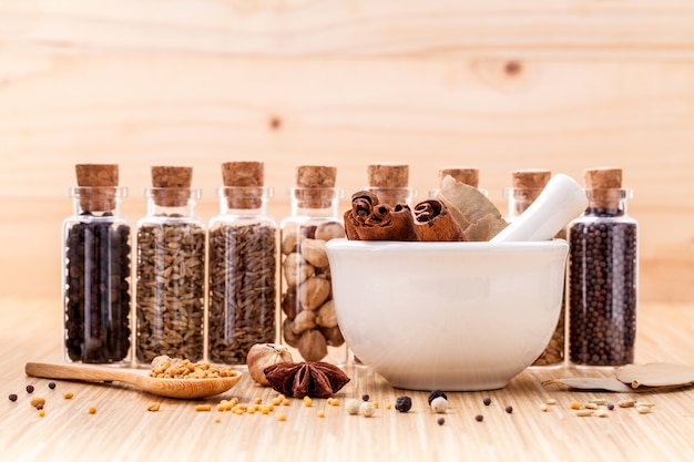 Assorted of spice bottles on wooden background.