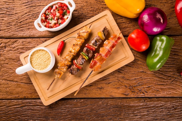 Assorted steak skewers on top of a board