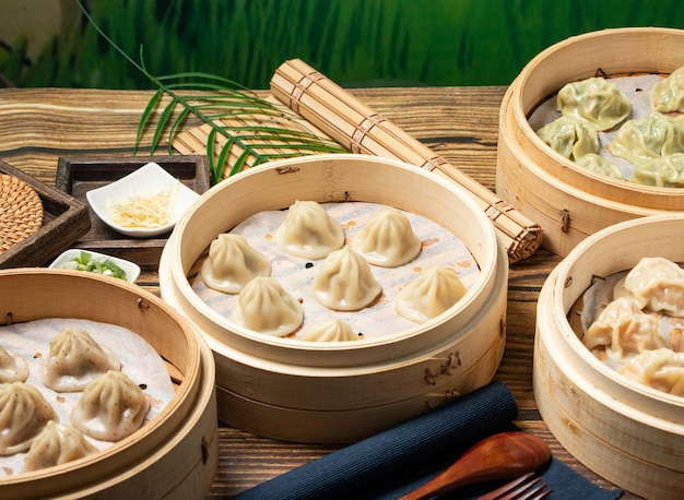 Assorted steamed sumplings Shrimp Dumplings Xiao Long Tang Bao Beef Soup Bun with leek green onion wood spoon and napkin served in a wooden dish side view of taiwan food