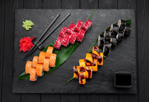 Assorted sushi nigiri and maki big set on slate A variety of Japanese sushi with tuna crab salmon eel and rolls