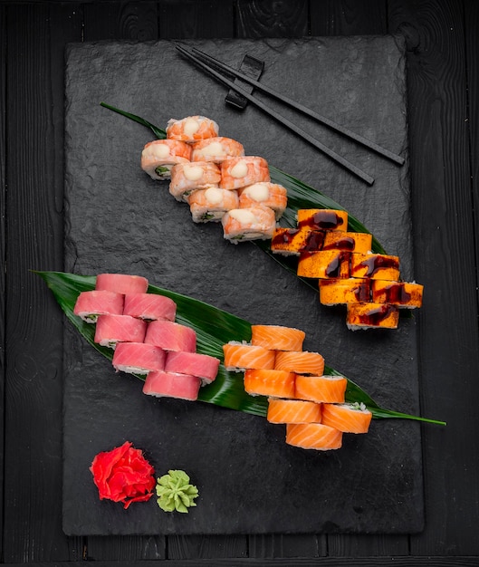 Assorted sushi nigiri and maki big set on slate A variety of Japanese sushi with tuna crab salmon eel and rolls