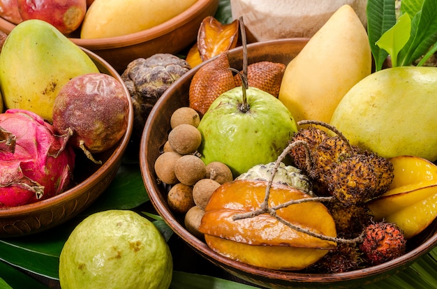 Assorted Thai tropical fruits on a dark wooden rustic background.