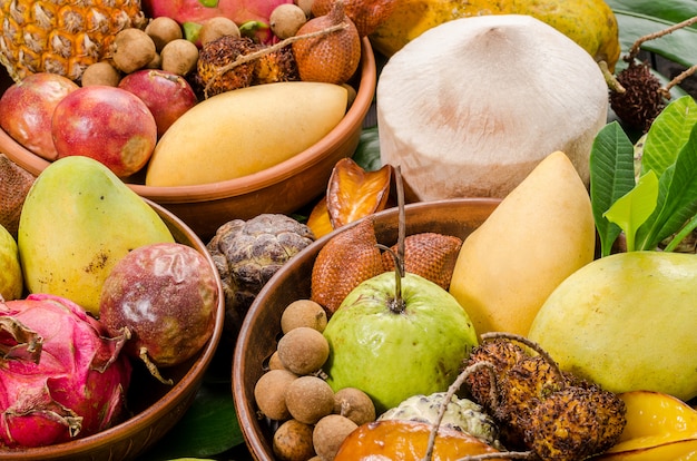 Assorted Thai tropical fruits on a dark wooden rustic background.