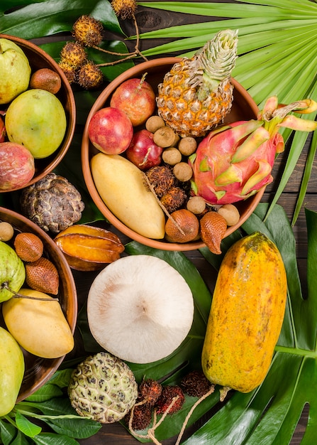 Assorted Thai tropical fruits on a dark wooden rustic background.