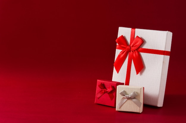 Assorted white gift boxes on red background Copy space