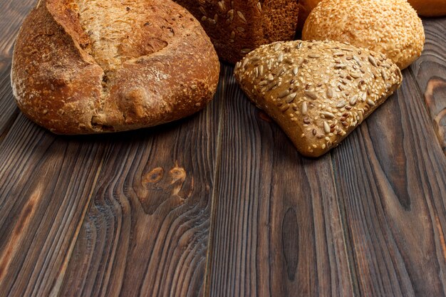 Assortment of baked bread on dark wooden.