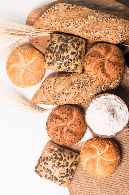 Assortment of baked bread with seeds on a white table background. Bakery. Food security concept.