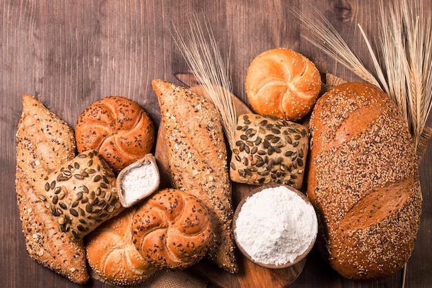 Assortment of baked bread with seeds on a wooden table background. Bakery. Food security concept.