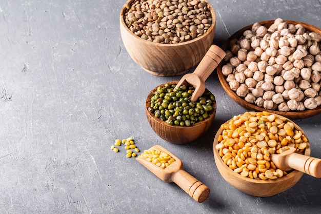 Assortment of beans, legumes on grey concrete background.