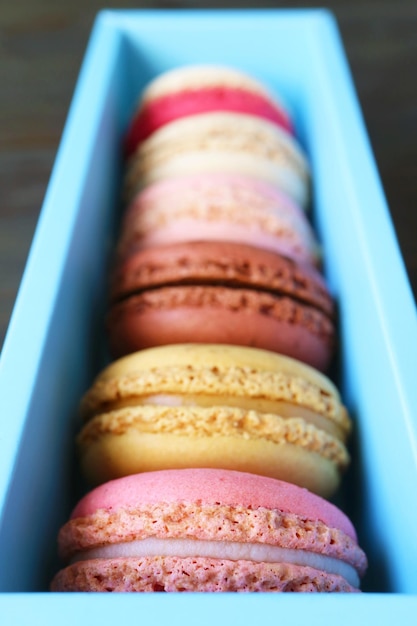 Assortment of beautiful colored Macaron pastries in light blue box