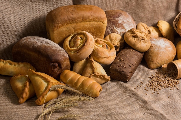 Assortment of bread ears and grains of wheat on wooden table Rustic style