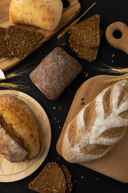 Assortment of breads on black background rye gluten free wheat seeded whole grain