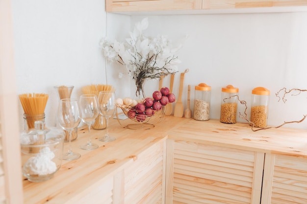 Assortment of cereals and pasta in glass jars and kitchen utensils on a wooden table Scandinavianstyle kitchen dried garlic