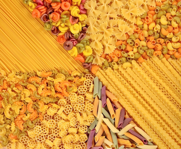 Assortment of colored uncooked Italian pasta as background texture