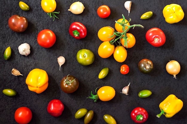 Assortment of colorful fresh vegetables on black surface