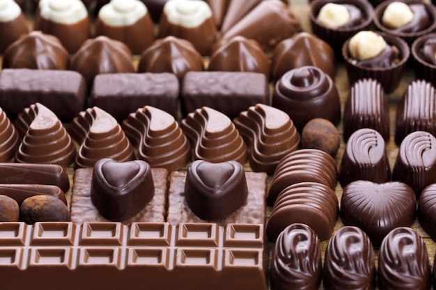 Assortment of delicious chocolate candies background, close up