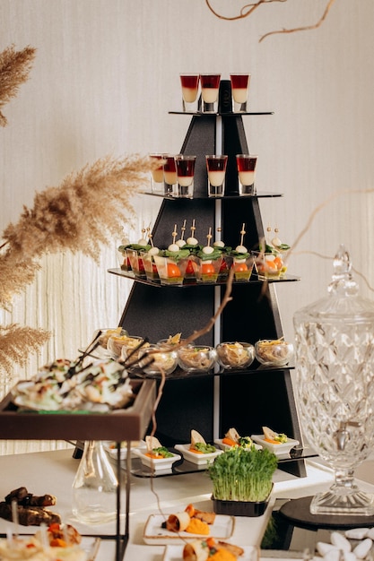 Assortment of delicious snacks on the open buffet festive table in restaurant catering plate