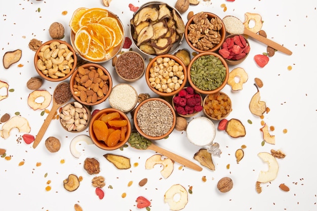 Assortment of dried fruits nuts and seeds on white background