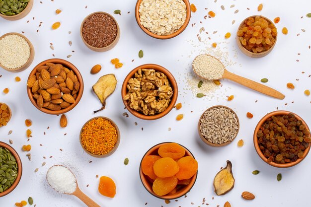 Assortment of dried fruits nuts and seeds on white background