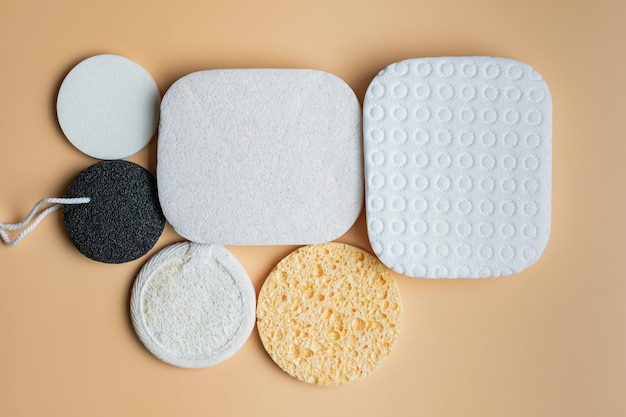 Assortment of Facial sponges on a beige background Round and square facial sponges made of natural ecological materials for hygienic self care