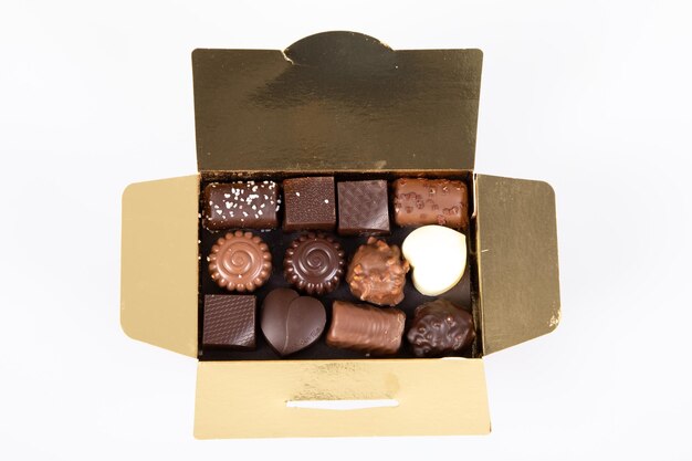 Assortment of fine milk black dark artisanal chocolate candies in small gift golden box