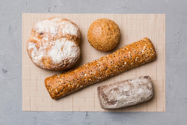 Assortment of freshly baked bread with napkin on rustic table top view Healthy unleavened bread French bread