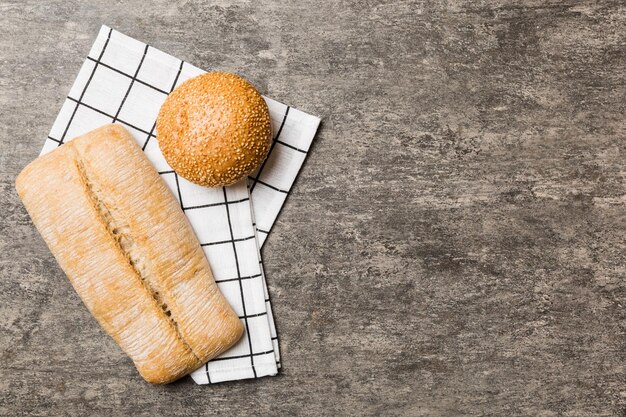 Assortment of freshly baked bread with napkin on rustic table top view Healthy unleavened bread French bread