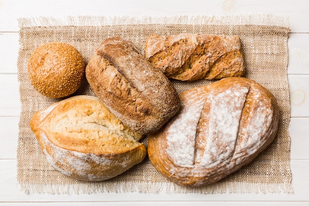 Assortment of freshly baked bread with napkin on rustic table top view Healthy unleavened bread French bread