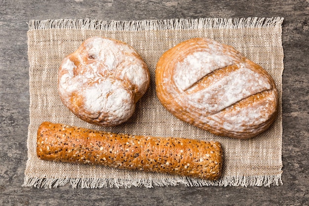 Assortment of freshly baked bread with napkin on rustic table top view Healthy unleavened bread French bread