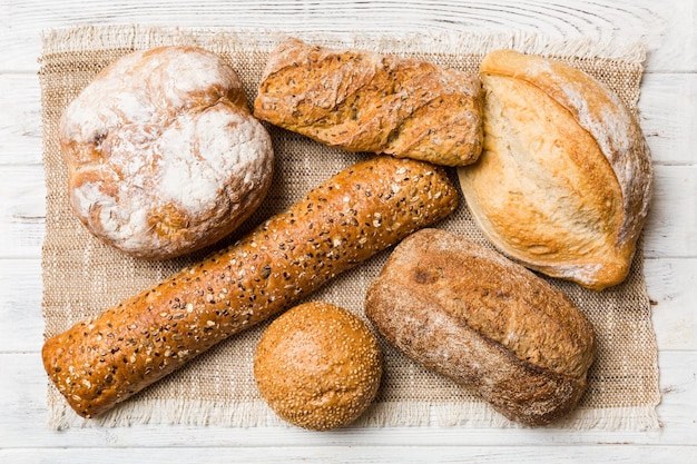 Assortment of freshly baked bread with napkin on rustic table top view Healthy unleavened bread French bread