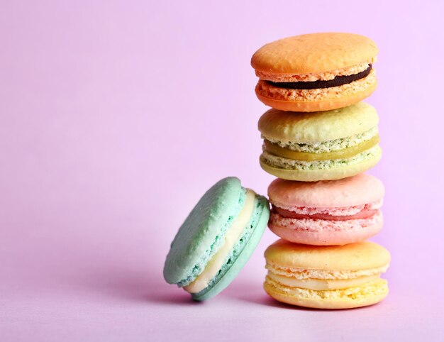 Assortment of gentle colorful macaroons on color background