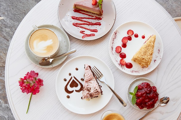 Assortment of natural vegan layered desserts piece of cakes with fresh fruits and berries Celebration assortment of cakes on the terrace Top view food