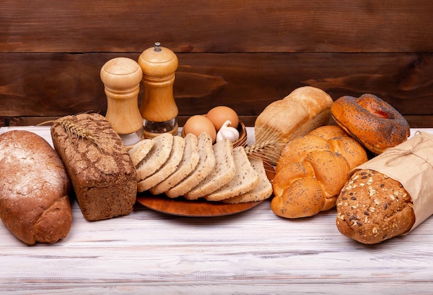 Assortment of tasty baked bread on dark and white background