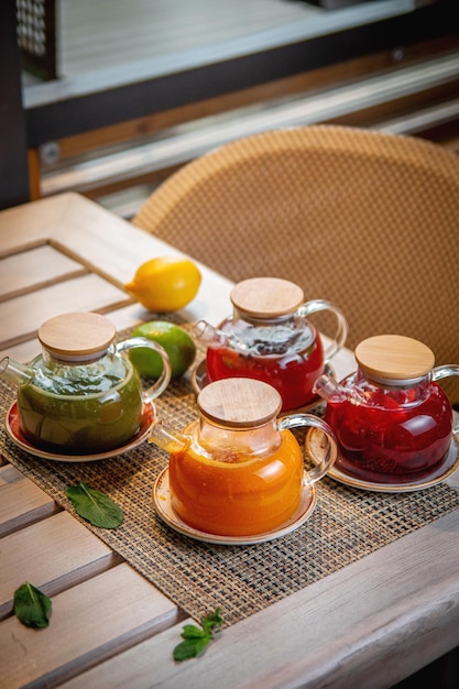 An assortment of teas in glass teapots on the summer terrace of the restaurant Ginger sea buckthorn and fruit tea