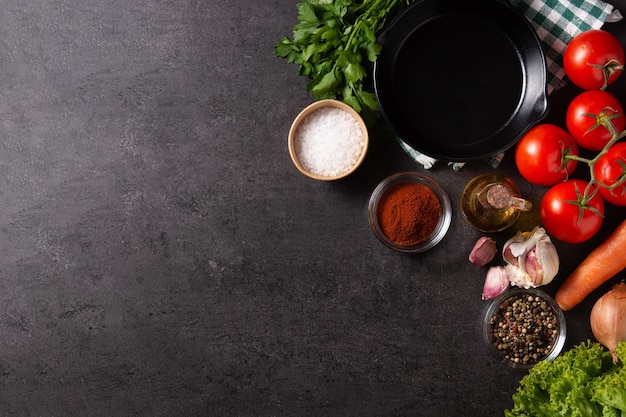 Assortment of vegetables herbs and spices on black background