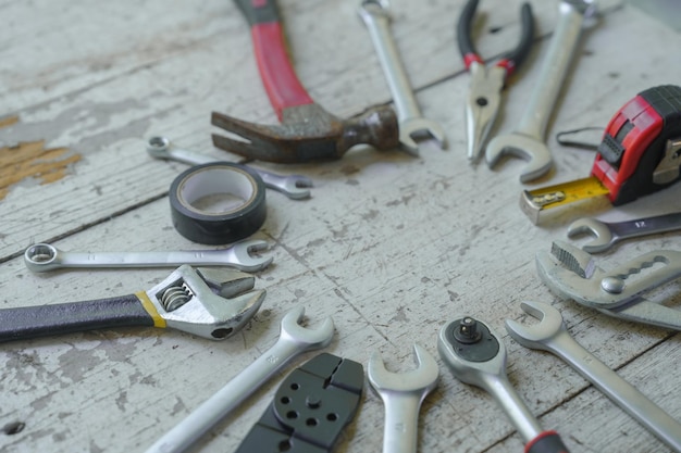 assortment of wellused hand tools spread out on a worn wooden surface indicative of a workspace