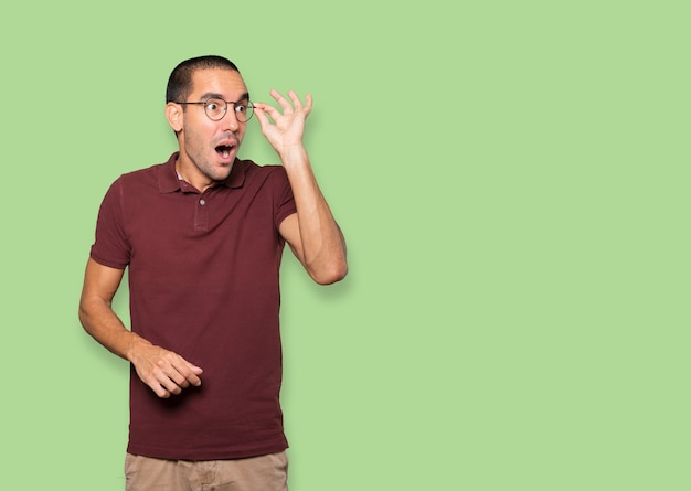 Astonished young man with a gesture of looking away