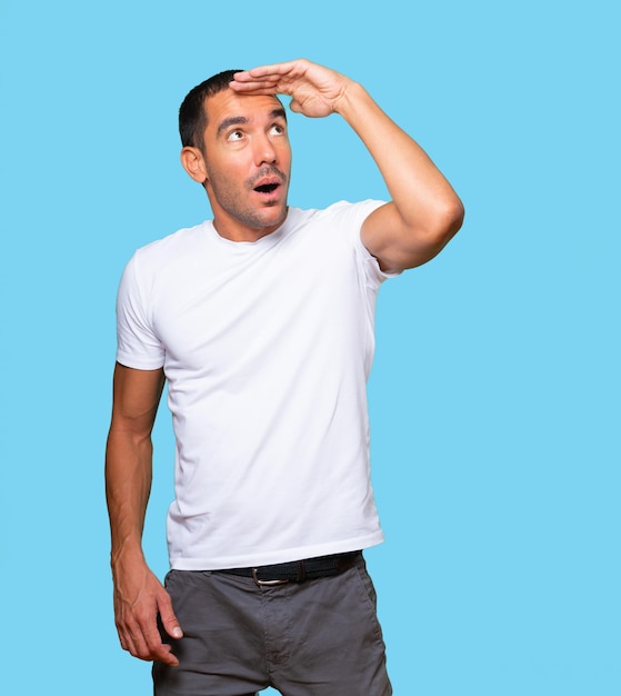 Astonished young man with a gesture of looking away